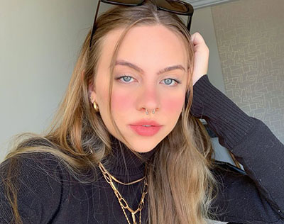 Foto ilustrativa de uma mulher loira com blusa preta, representando uma Sugar Baby.